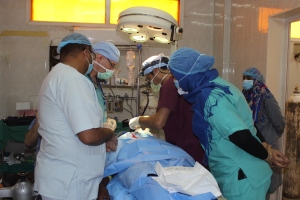 Dr. Irfan Galaria works under the watchful eye of two dental students